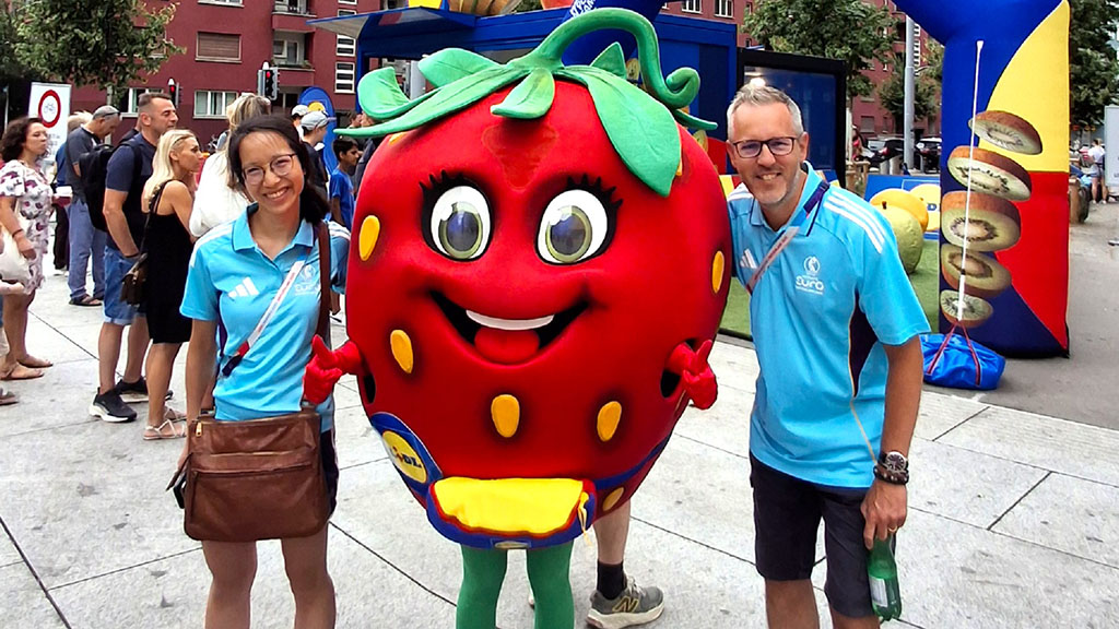 Lan Do and Alex Stone with a sponsor mascot in the form of a human strawberry